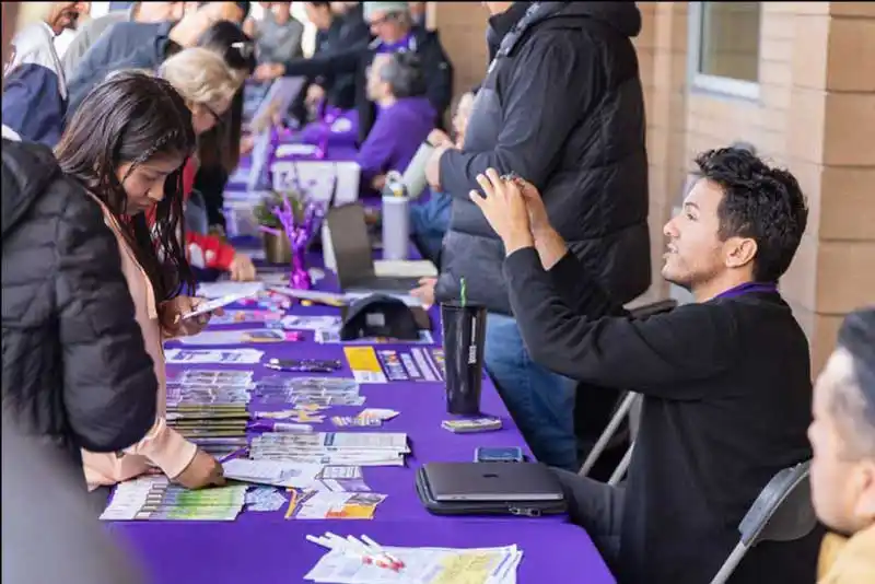 students and staff at event table