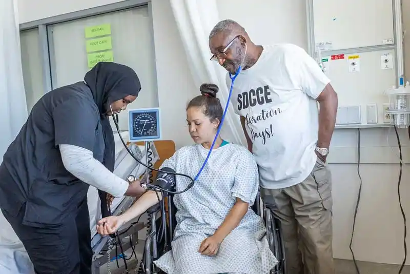 2 CNA students and Kenny Parker