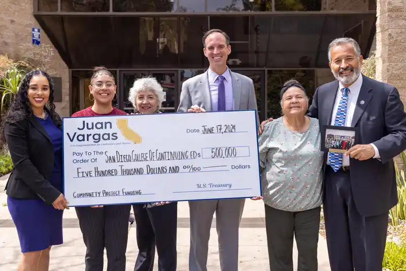 A group of people with a large check