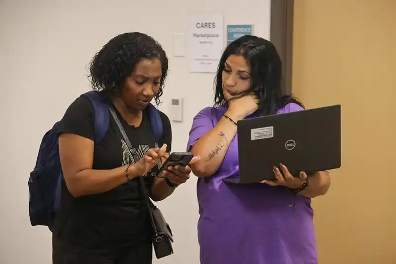 student being helped by woman with laptop