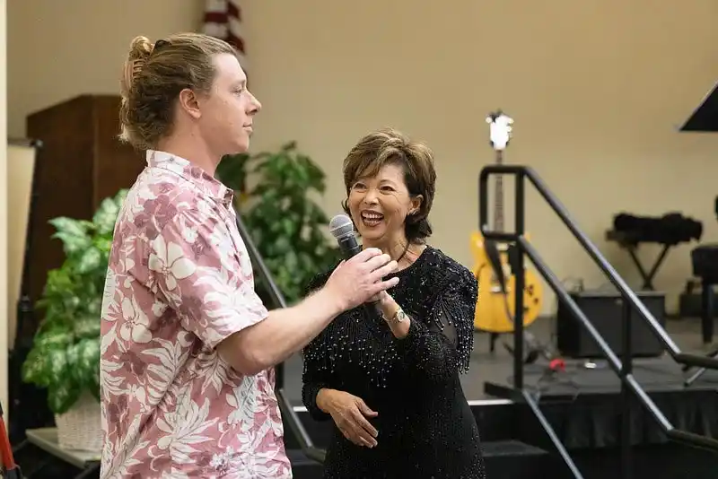 two people one handing a mic to the other