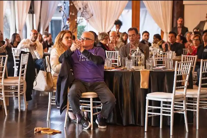 people sitting at tables clapping