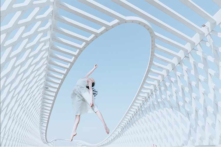 A dancer jumping on a bridge