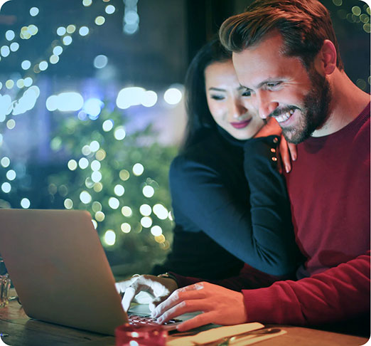 Man and woman smiling at a computer