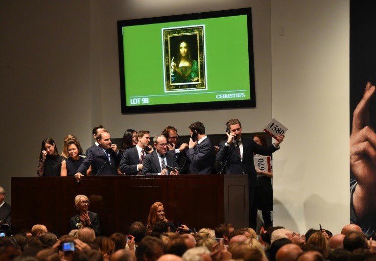 Empleados de la casa de subastas Christie's reciben ofertas para "Salvator Mundi" de Leonardo da Vinci, el pasado 15 de noviembre de 2017 en Nueva York. LA PRENSA/ AFP / Timothy A. Clary