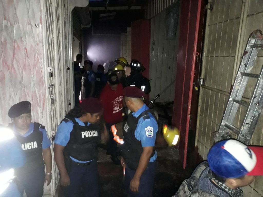 Bomberos y comerciantes continúan trabajando para controlar el incendio en el sector de los vaho en el mercado Oriental. LA PRENSA/ W. Narváez.