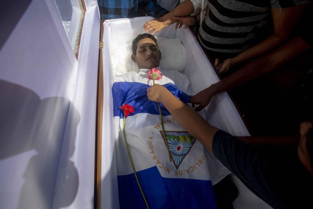 Un joven pone una flor sobre el joven Ezequiel Gamaliel Leiva, de 26 años de edad, durante su entierro en el cementerio "Milagro de Dios", a las afueras de Managua (Nicaragua) el pasado 18 de septiembre de 2018. LA PRENSA/ EFE