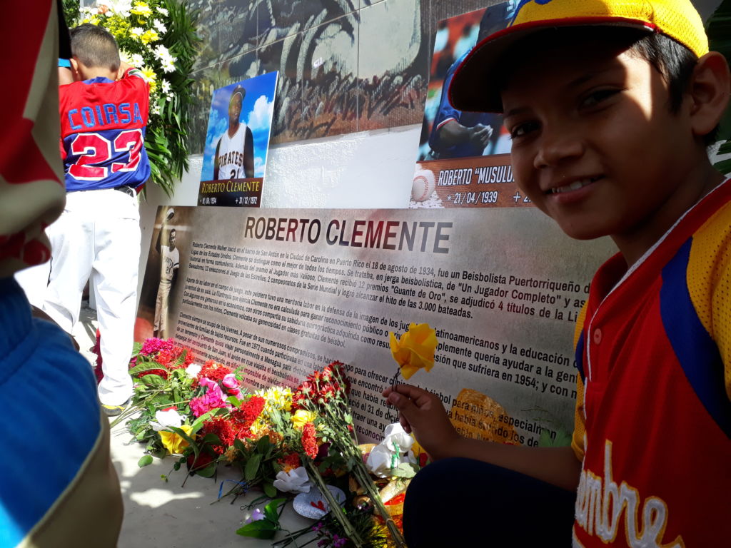 Los niños depositaron una flor a Roberto Clemente en su monumento ubicado en el parque Luis Alfonso esta mañana. Foto Rosa Membreño