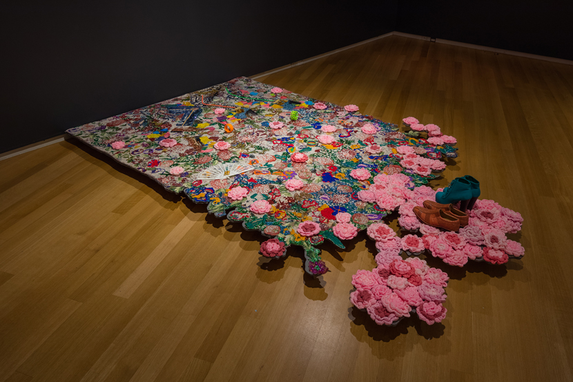 Ebony G. Patterson, Where We Found Them, 2014; mixed media jacquard weaved tapestry with jewelry, shoes, gold chains, tassels, 100 crochet flowers, 8ft x 6ft; installation view of Dead Treez, installation view, John Michael Kohler Arts Center in Sheboygan, Wisconsin; courtesy Monique Meloche Gallery Ebony G. Patterson, Where We Found Them, 2014; mixed media jacquard weaved tapestry with jewelry, shoes, gold chains, tassels, 100 crochet flowers, 8ft x 6ft; installation view of Dead Treez, installation view, John Michael Kohler Arts Center in Sheboygan, Wisconsin; courtesy Monique Meloche Gallery
