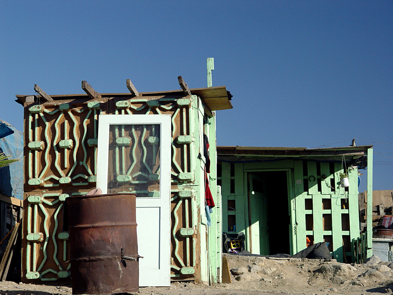 Ingrid Hernández, Tijuana Comprimida, Tijuana 2004. Ingrid Hernández takes photos of the homes of Tijuana's working poor. Many are made from refuse from US factories, highlighting the complicated relationships between the United States and Mexico at the border.