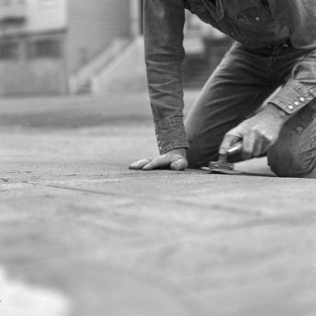 David Ireland repairing the sidewalk, 500 Capp Street, 1976; photo: Tom Marioni; image courtesy of The 500 Capp Street Foundation.