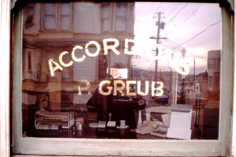 Front window, with gold leaf sign left by Paul Greup, the Swiss accordion maker who previously own 500 Capp Street; photo: David Ireland; image courtesy of The 500 Capp Street Foundation.