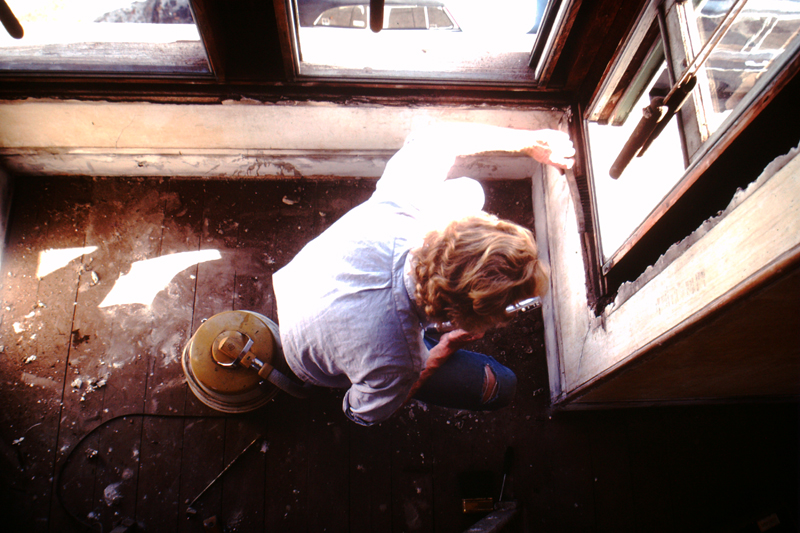 David Ireland cleaning the window frame of the front parlor room at 500 Capp Street, c.1976; photo: Steven Kayfetz; image courtesy of The 500 Capp Street Foundation.