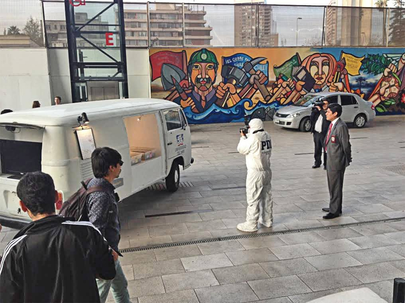 A police detective documents Francisco Papas Fritas’ Ad augusta per angusta (2014) at the Chilean Ministry of Culture.