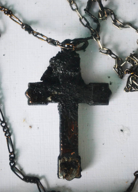 Chain with metallic cross and pieces of burned skin worn by deceased inmate Jorge Manríquez Pizarro at the time of the fire, framed in a 30x20x5 cm box and displayed as part of Francisco Papas Fritas’ Deber (Duty) (2012), which explores the responsibility of the Chilean state in the deaths of eighty-one inmates in the 2010 San Miguel prison fire.