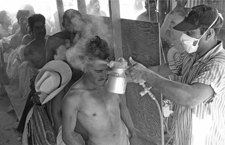 A Bracero being fumigated with DDT. Leonard Nadel, El Paso, Texas, 1956. Collection of National Museum of American History.