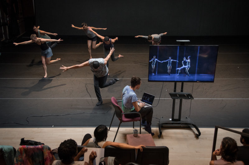 Rashaun Mitchell teaching repertory to the dancers while Silas Riener shares footage with the commissioned artists. Photo: Hillary Goidell.