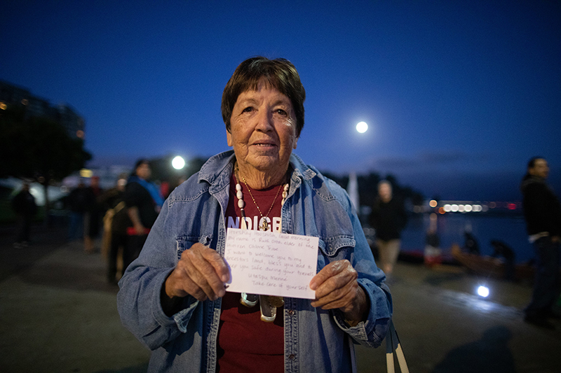 Ruth Orta welcoming canoes ashore at the Alcatraz Canoe Journey. Photo: Marissa Leshnov.