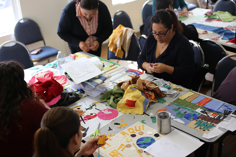 Women from the Latina Center’s Leadership group participate in a social justice quilt workshop, 2018. In August 2018 the Richmond Art Center and Social Justice Sewing Academy partnered to run a workshop at The Latina Center in Richmond. Women from the leadership program learned how to visualize social justice issues to design a quilt. This quilt was included in an exhibition at the Richmond Art Center, Empowering Threads, in winter 2019.