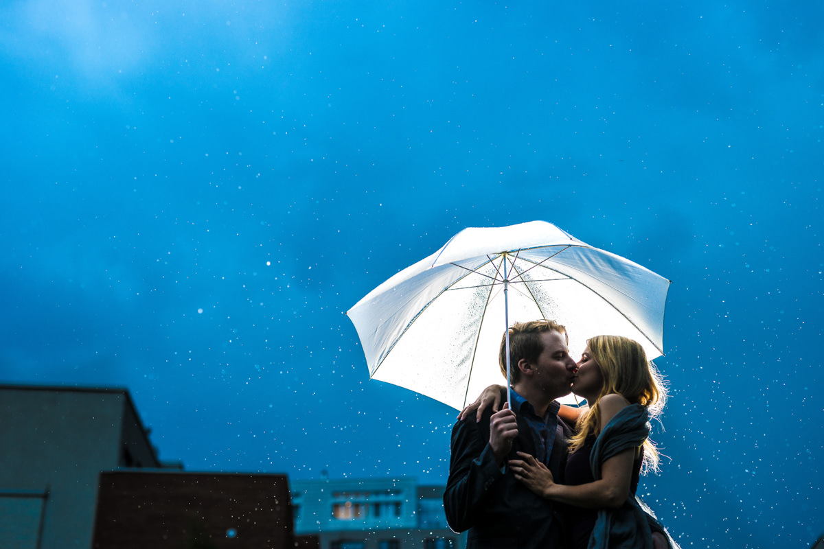 Couple de mariés sous un parapluie blanc