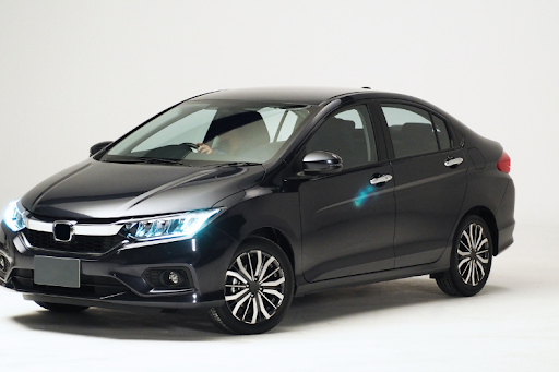 Black sedan car with LED headlights displayed in a studio setting on a white background.