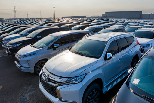 Large parking lot filled with cars lined up.