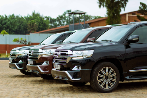 Row of black and maroon SUVs parked in a lot, showcasing large luxury vehicles with chrome detailing.