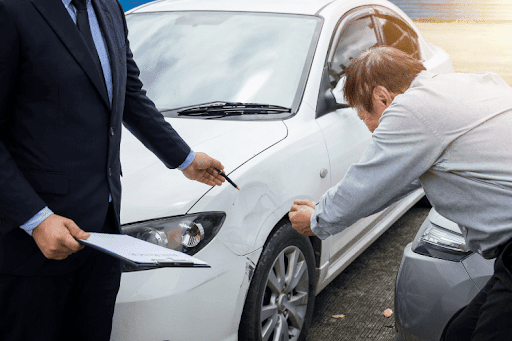 Man reviewing car damage with an insurance representative after an accident.