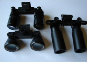 A 2.5x Galilean binocular loupe (lower left), and a 4x (top left) and a 6x (right) Keplerian binocular loupe shows the longer barrel length for higher magnification Keplerian binocular loupes, and the wider diameter objective lens of the Galilean binocular loupes.