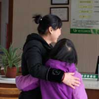 Saying goodbye to the orphanage staff for the 2nd time in her life.