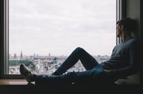 man looking out window