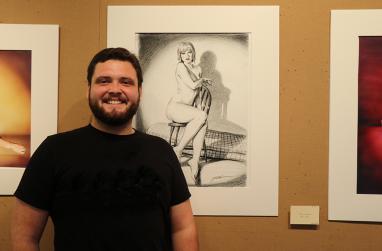 Picture of Dylan Gerber in front of one of his pieces of art.