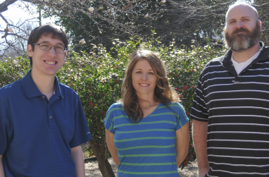Kiefer Burkhard, Beth Powell and Dr. James Finck standing in the garden between Troutt and Austin Halls.