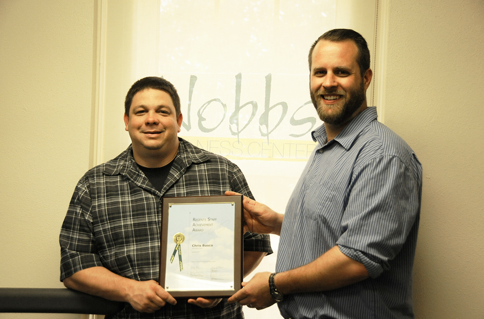 Chris Basco (left), assistant dean of students and director of health services, receives his Staff Achievement award from Adam Heilman, the 2012-13 Employee of the Year.