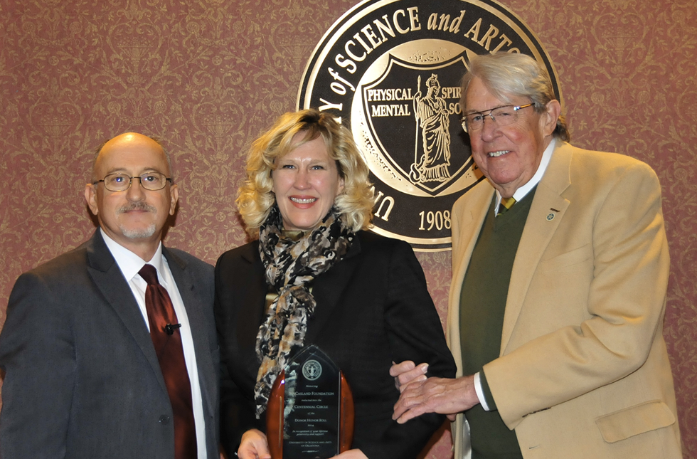 Dr. Michael Nealeigh and President John Feaver present McCasland executive director Barbara Braught with an award.