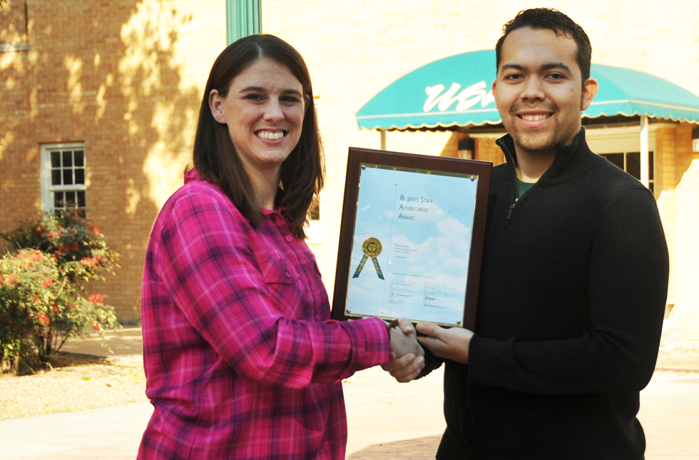 Ashley Donald awards Roland Nunez with the staff achievement award