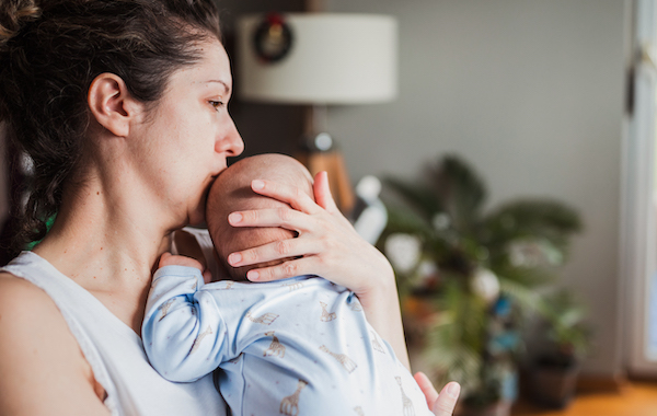 Stressed out mom holding newborn baby