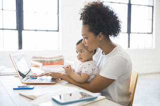 mom at computer with baby on her lap