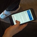 student reading textbook on their phone picture