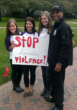 UWPD officer and students with a sign saying, "Stop domestic violence!"