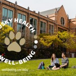 Two students sitting and talking on the HUB lawn