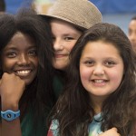 Three children huddled close together and smiling