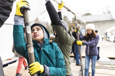Volunteers help raise a tent during Tent City 3's move-in