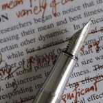 Type written text with red editing marks and a pen.