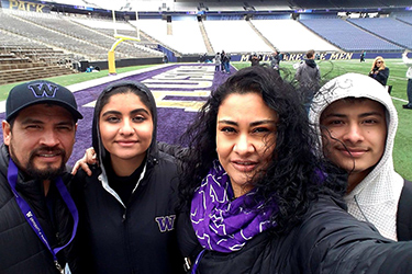 a family posing for a selfie at the Husky Stadium