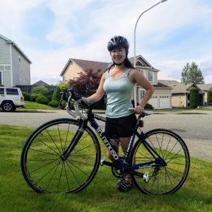 A photo of Sara Lee standing with her bike.