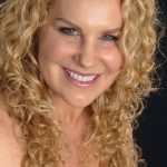 A photo of Janelle Veteri, cycling master trainer. Janelle is smiling and wearing a black top.