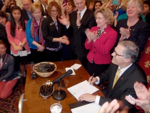 REAL Hope Act Onlookers cheer as Governor Inslee signs SB 6523.