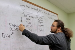 Mark works on a math problem in one of the study rooms at the Odegaard Library.