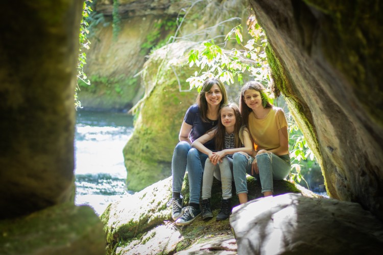 Jane Harrell sits with her two daughters, Scarlett, 9, and Sydney, 13, on a boulder near the Green River.